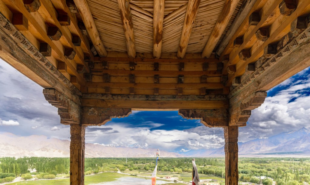 Traditional Ladakhi wooden architecture with mountain valley view
