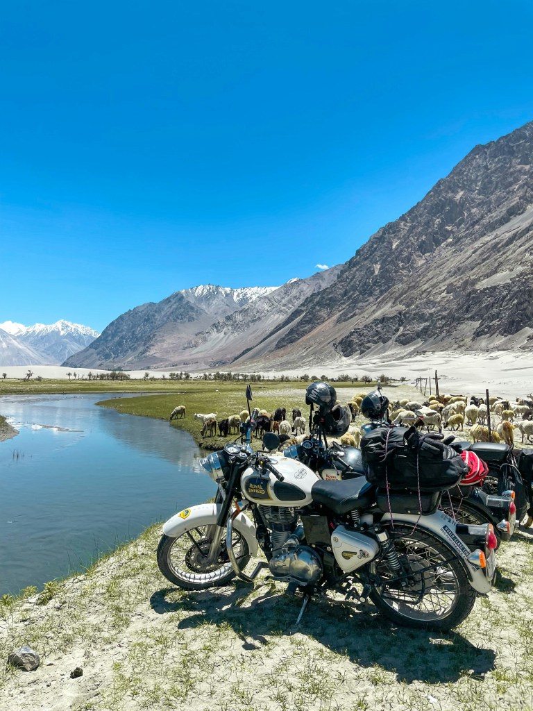 Royal Enfield motorcycle beside a mountain lake in Ladakh